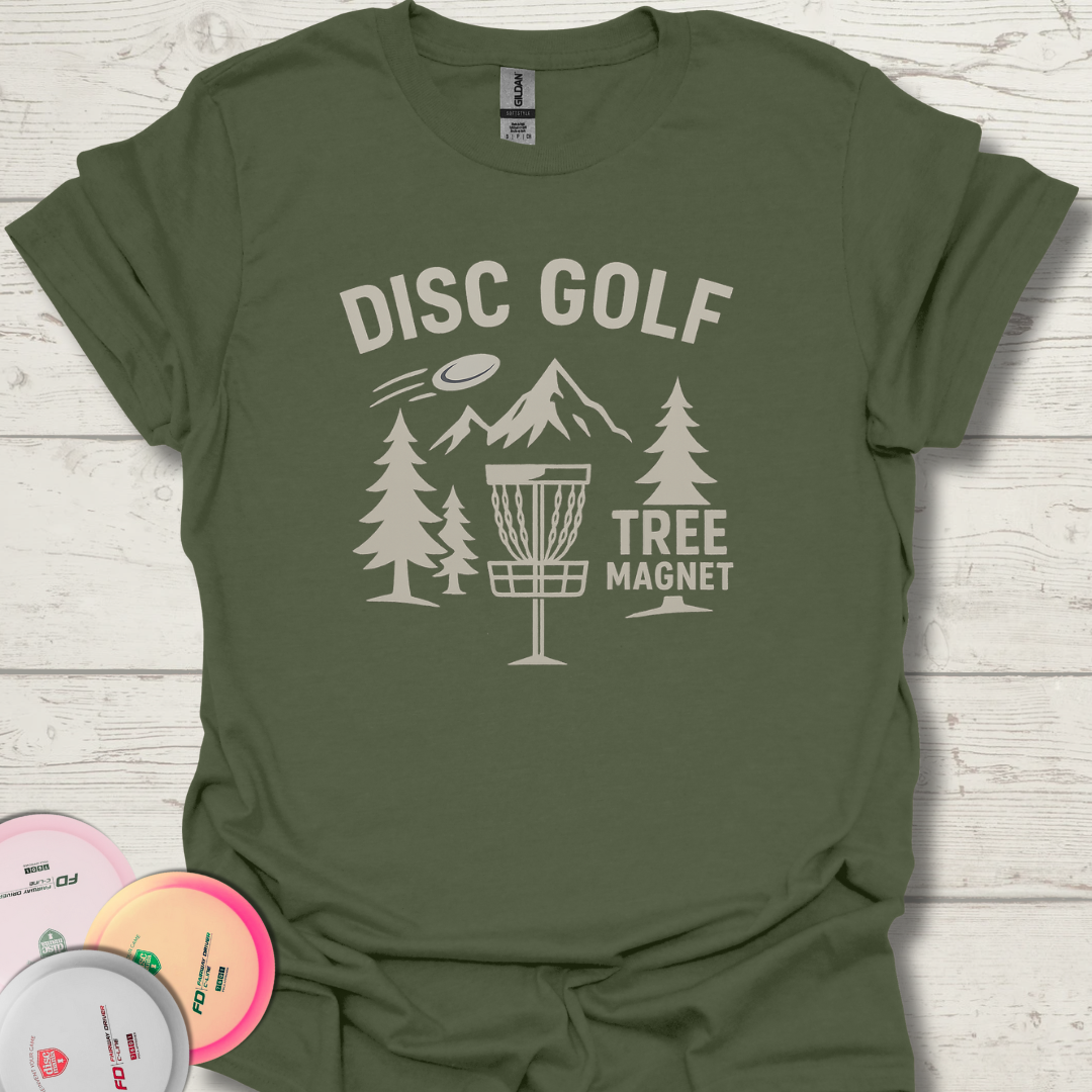 Close-up of Tree Magnet disc golf graphic with trees and basket. Disc golfer wearing Tree Magnet funny disc golf shirt in the woods.