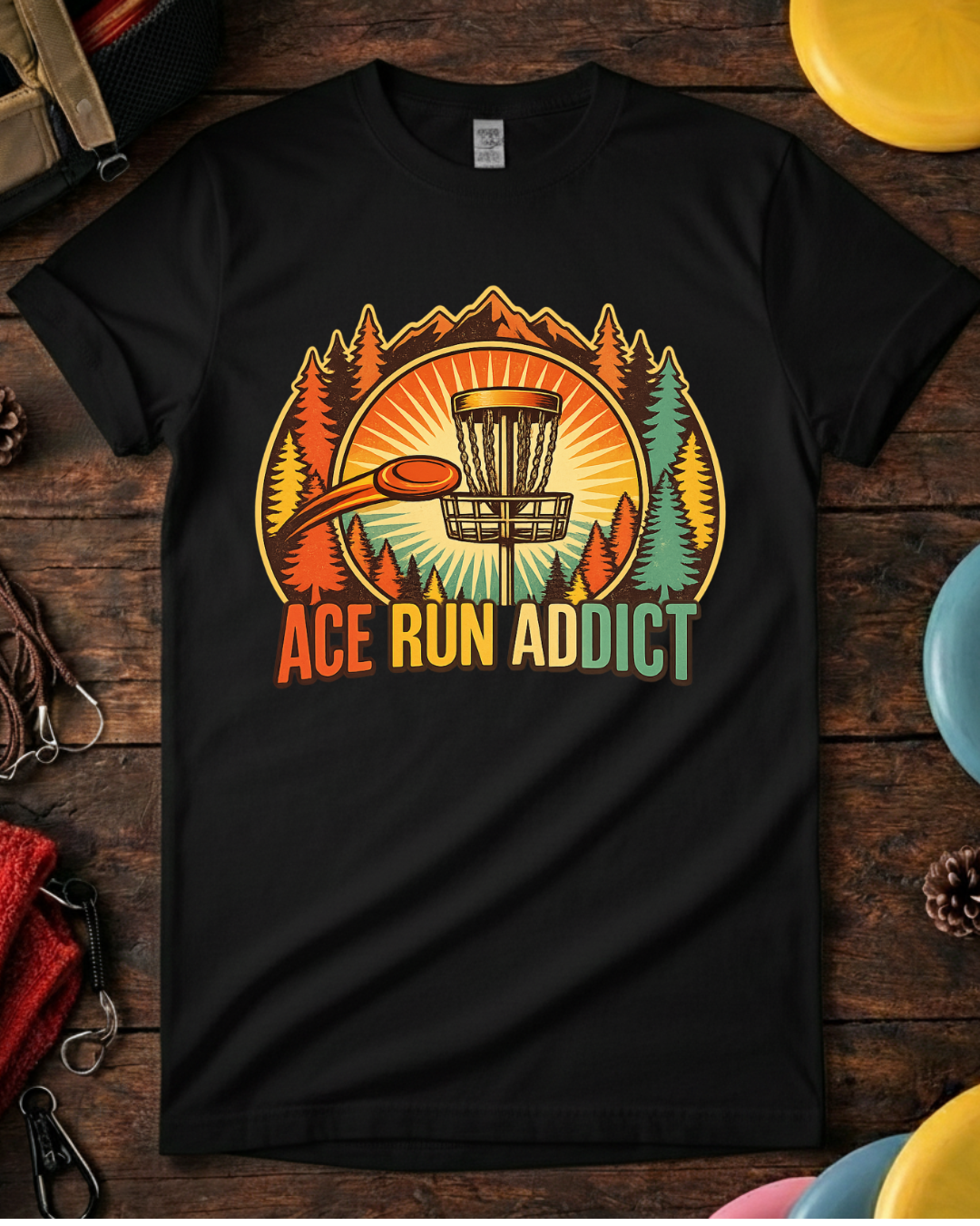 Disc golf tee that says Ace Run Addict with flying disc and sunset. Retro ace run disc golf shirt with mountains, trees and basket.
