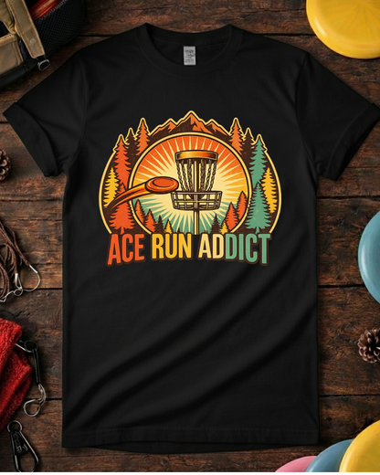 Disc golf tee that says Ace Run Addict with flying disc and sunset. Retro ace run disc golf shirt with mountains, trees and basket.