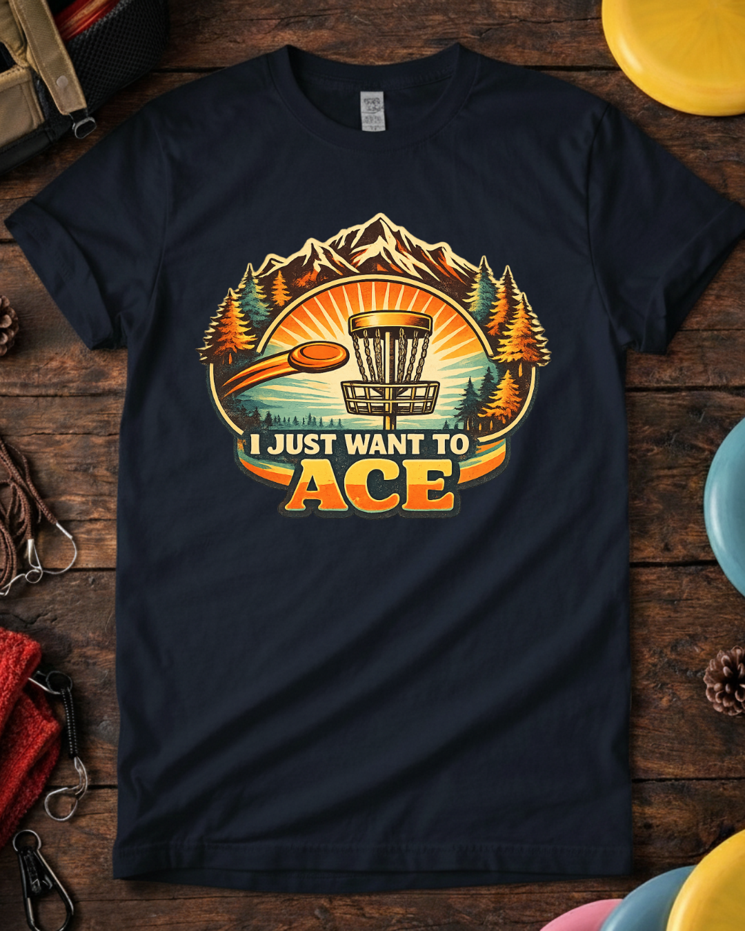 I Just Want To Ace disc golf shirt with retro mountain and basket design.