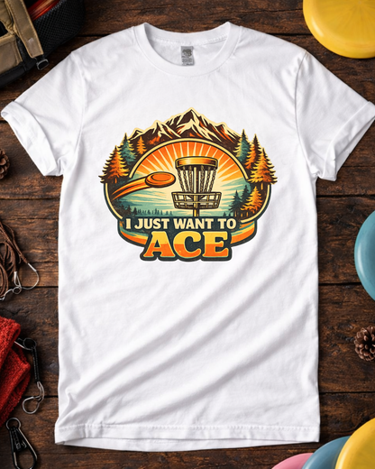 White I Just Want To Ace funny disc golf t-shirt on wooden background.
