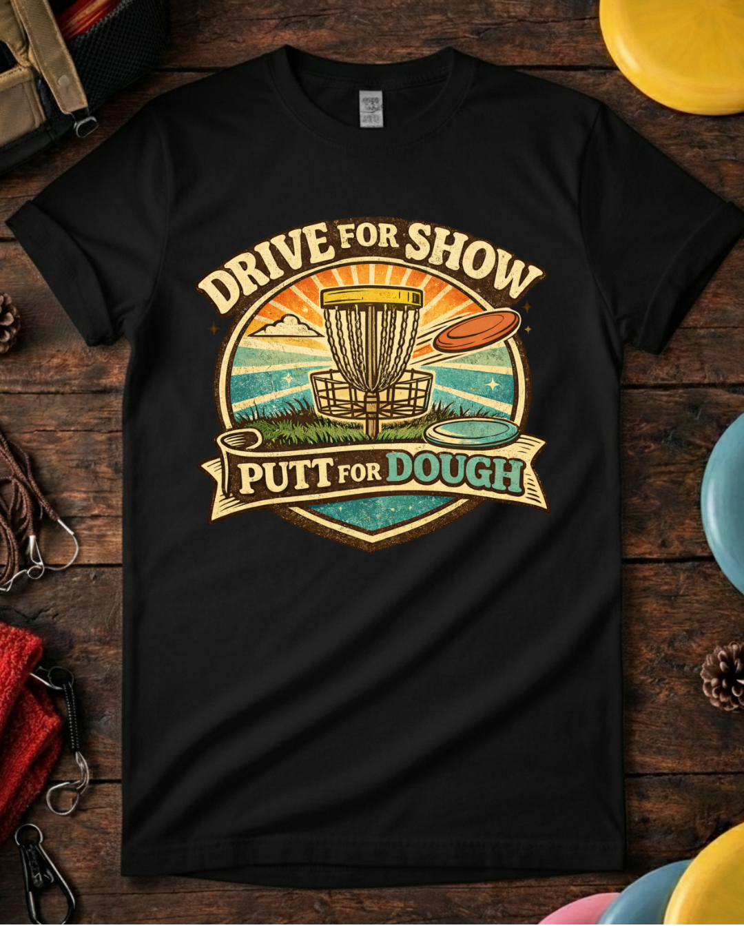 Unisex Drive For Show Putt For Dough disc golf shirt laid flat with discs.