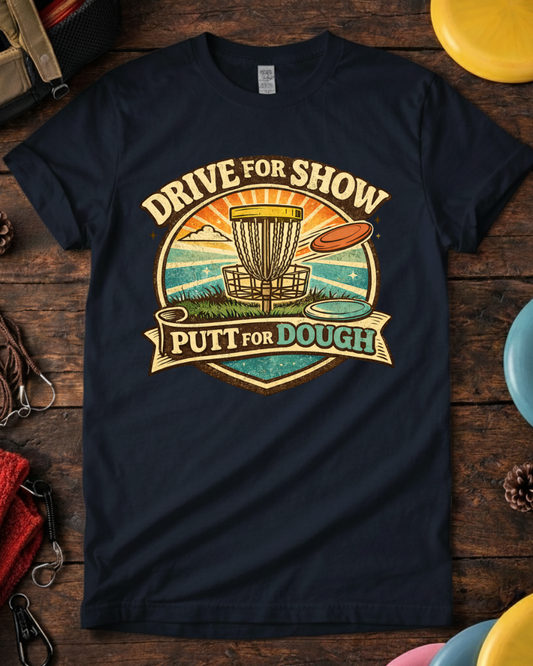 Drive For Show Putt For Dough disc golf shirt with retro basket design. Navy Drive For Show Putt For Dough funny disc golf t-shirt on wooden background.