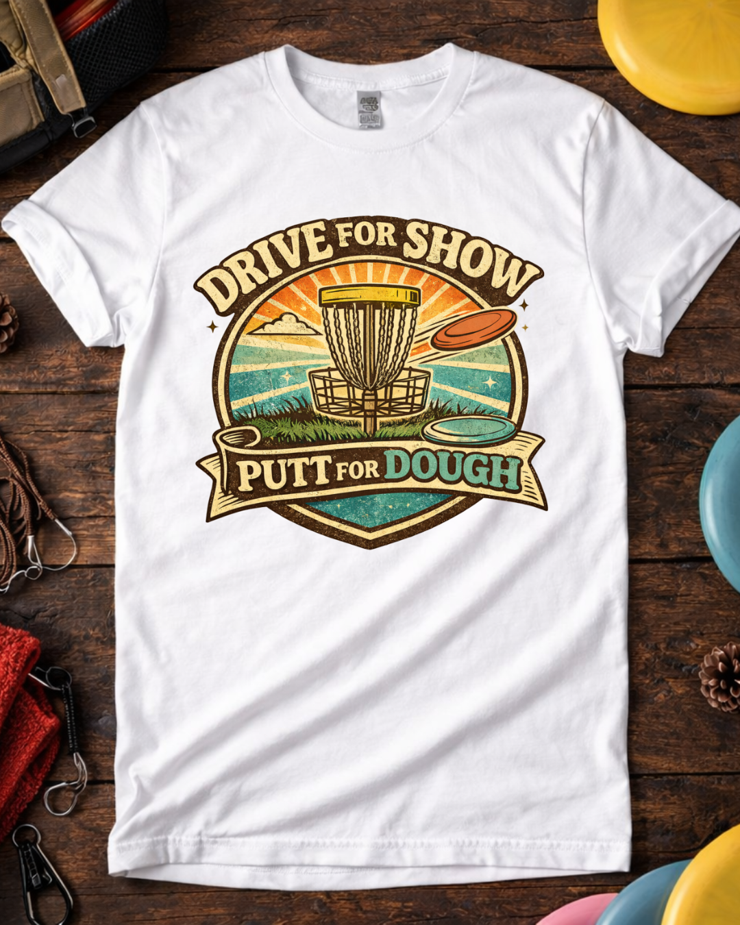 Disc golf tee that says Drive For Show Putt For Dough with sunset and water graphic.